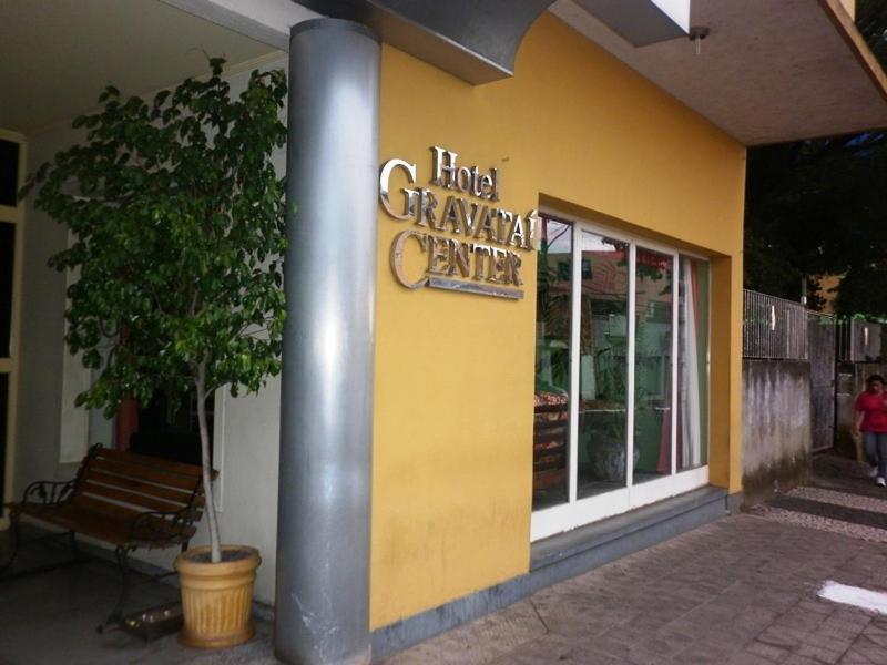 a yellow building with a sign for a ring garage center at Hotel Gravataí Center in Gravataí