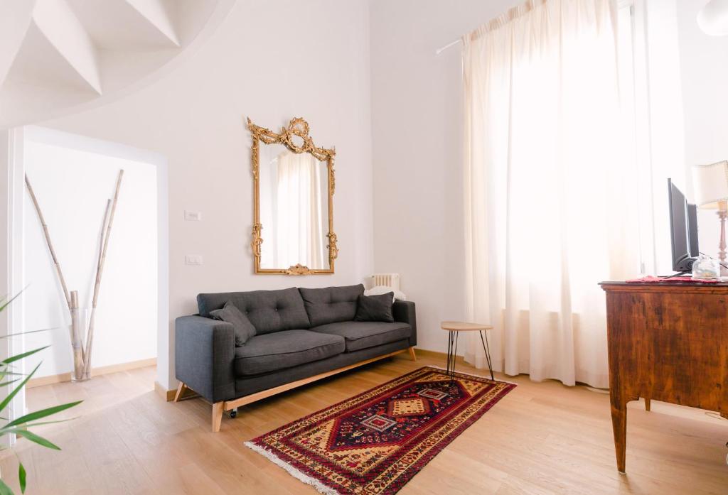 a living room with a couch and a mirror at Grande, moderno appartamento in edificio storico in Bologna