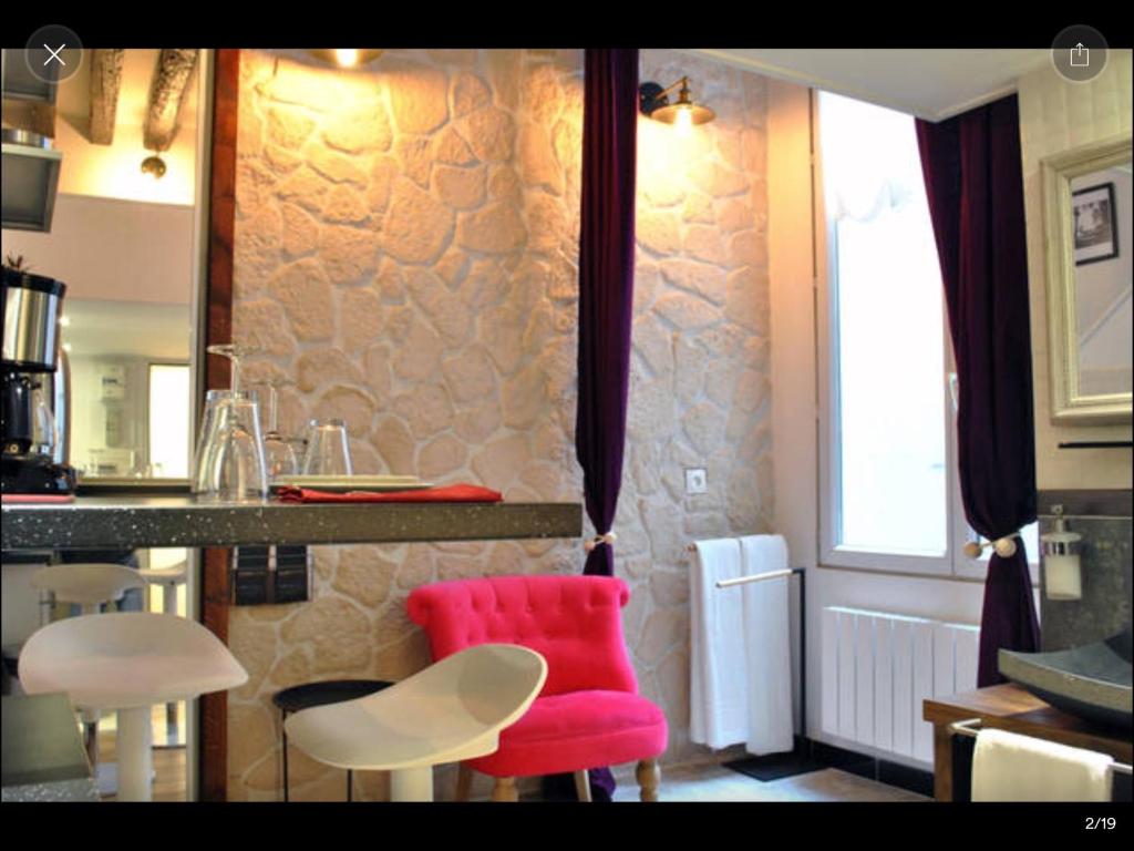 Una cocina con una silla roja y un mostrador. en Cosy Marais Paris, en París
