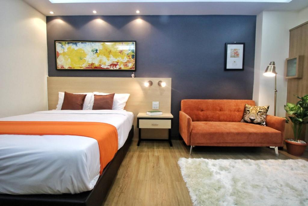 um quarto de hotel com uma cama e uma cadeira em Modern Studio in Nimman - Walking Distance to Mall em Chiang Mai
