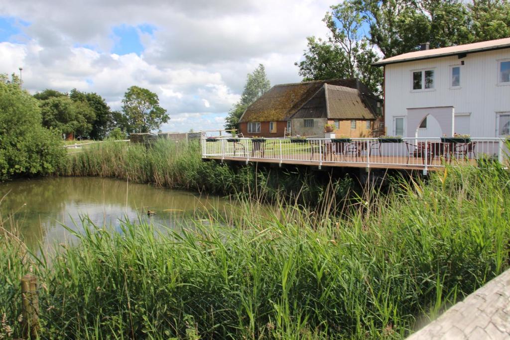 a house and a bridge over a river at Grünes Örtchen an der Nordsee in Witzwort