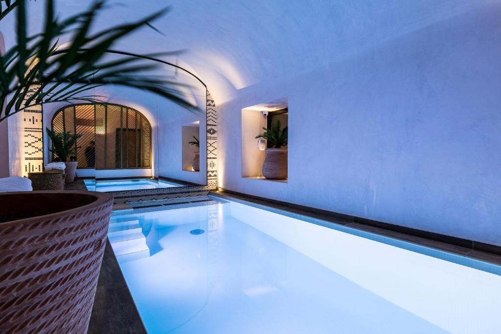 una gran piscina en una habitación blanca con en Laz' Hotel Spa Urbain Paris en París