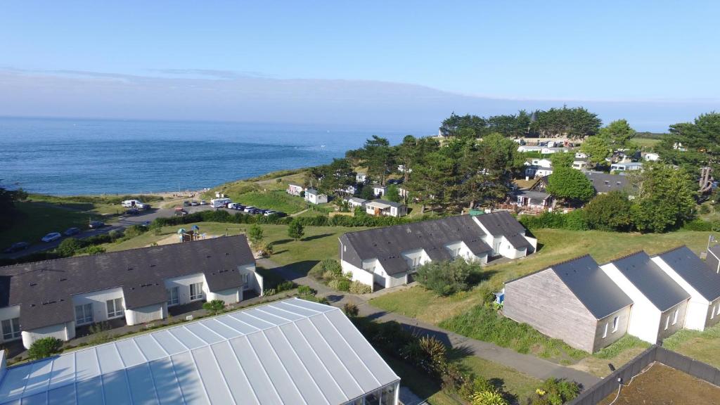 an aerial view of roofs of houses and the ocean at VVF La côte d'Emeraude Saint-Cast-le-Guildo in Saint-Cast-le-Guildo