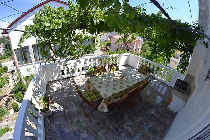 a table and chairs on top of a balcony at Sloth in Rab