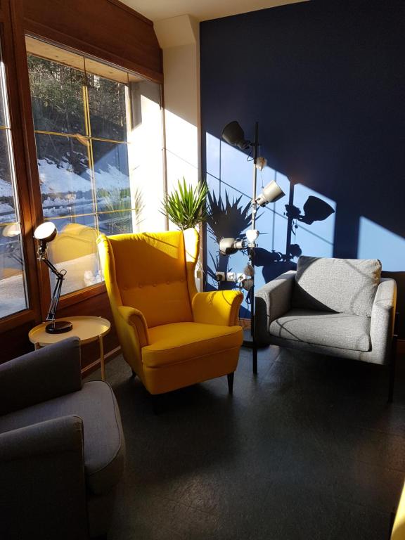 a living room with a yellow chair and a couch at L'Atelier du Rêve in Brides-les-Bains