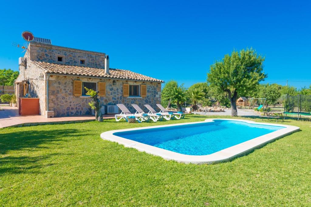 a villa with a swimming pool in front of a house at Finca Can Roig 113 by Mallorca Charme in Alcudia