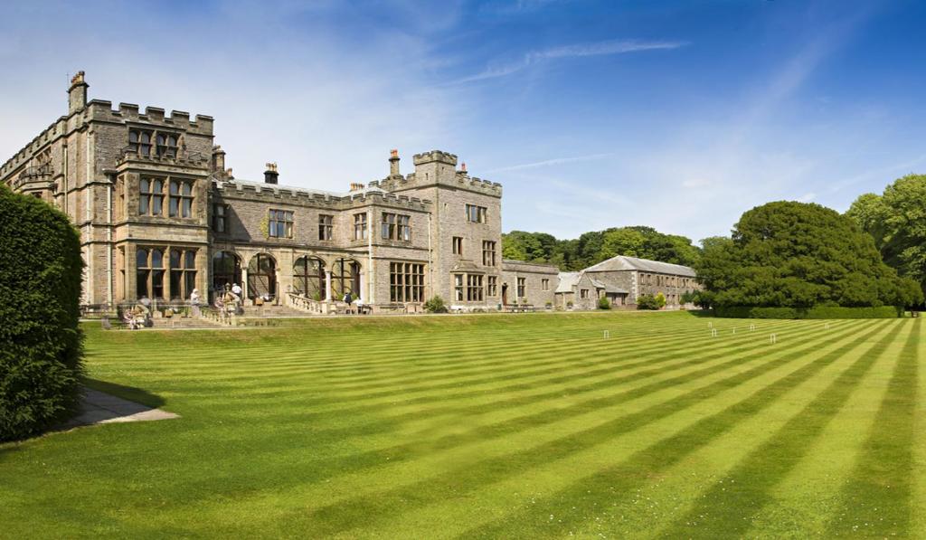 un antiguo castillo con un gran campo de césped en Armathwaite Hall Hotel & Spa, en Bassenthwaite