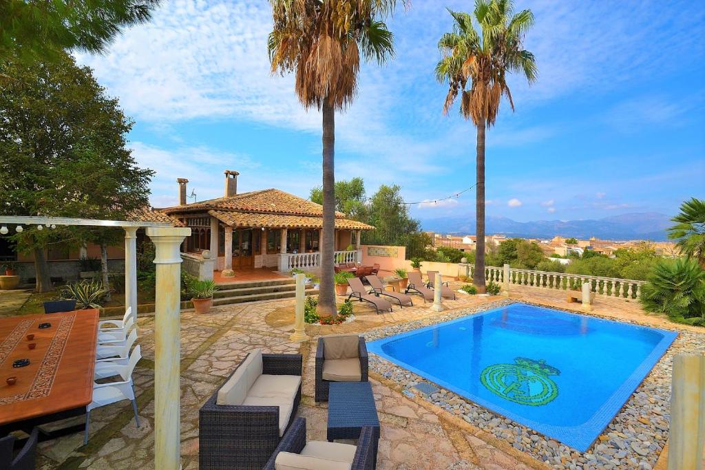 una casa con piscina y palmeras en Villa Can Bisbe 187 by Mallorca Charme, en Muro