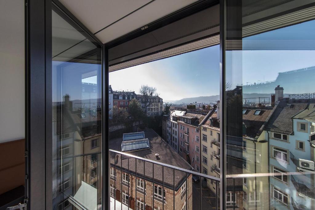 a view of a city from an apartment window at Royal Hotel Zurich in Zurich