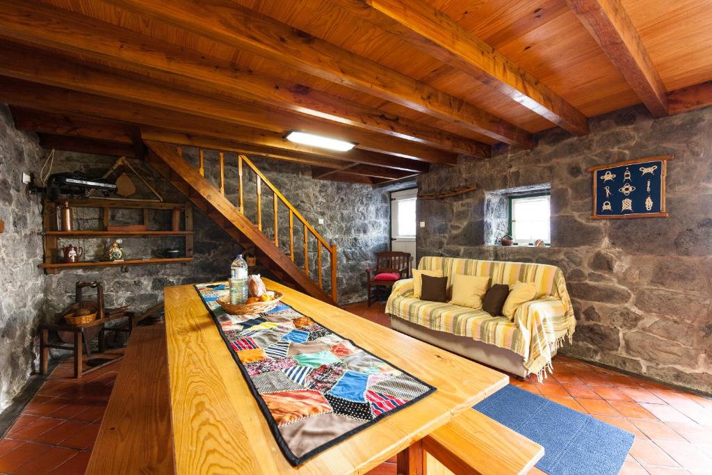 a living room with a wooden table and a couch at Adega Lopes in Santo Amaro