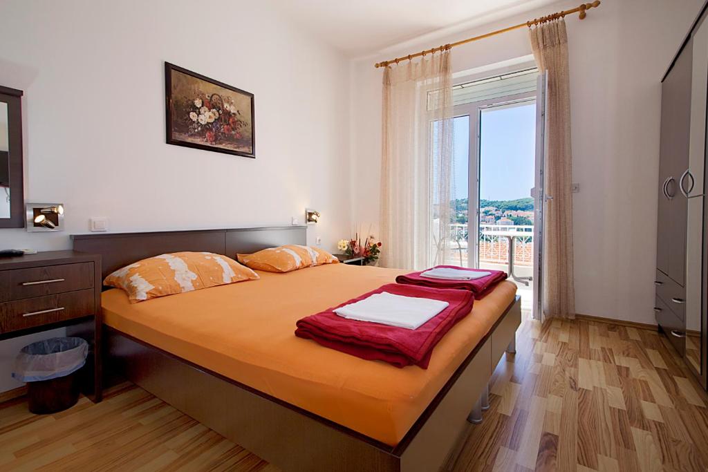 a bedroom with a bed and a large window at Guesthouse Victoria in Dubrovnik