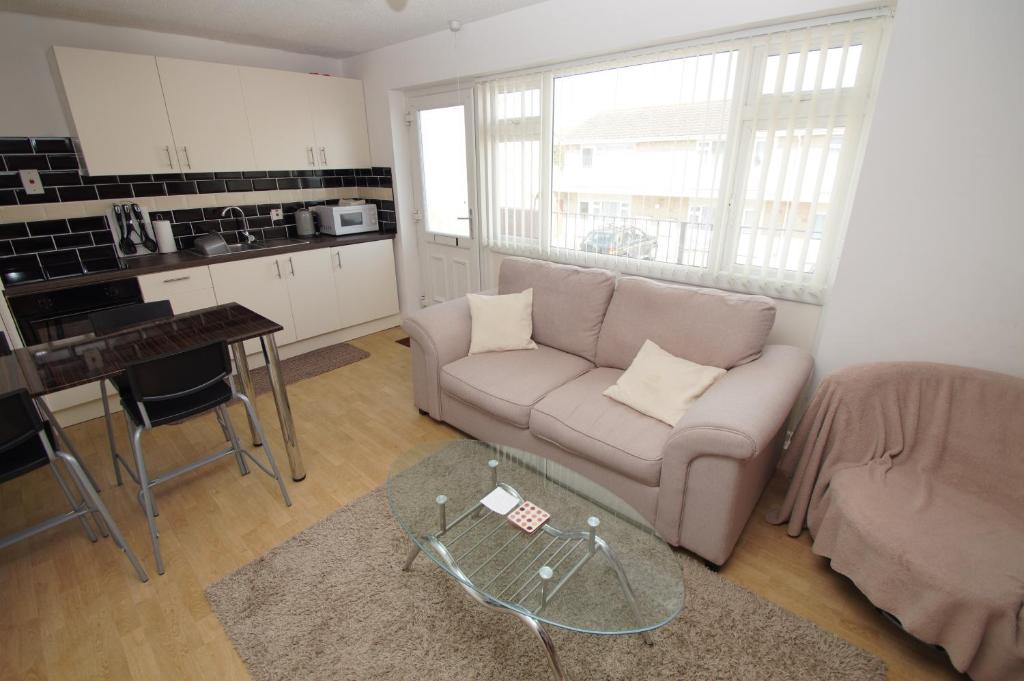 a living room with a couch and a table at 2 Bed Apartment w/private access to 7 miles of sandy beach - Sleeps 4 in Brean