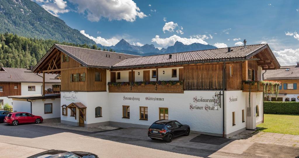 a large building with a car parked in a parking lot at Pension Krüner Stub´n in Krün