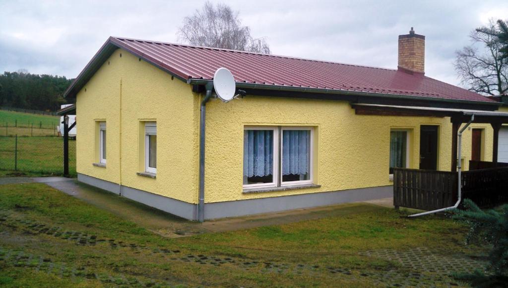BestenseeにあるFerienappartements Am Weinbergの赤屋根の黄色い家