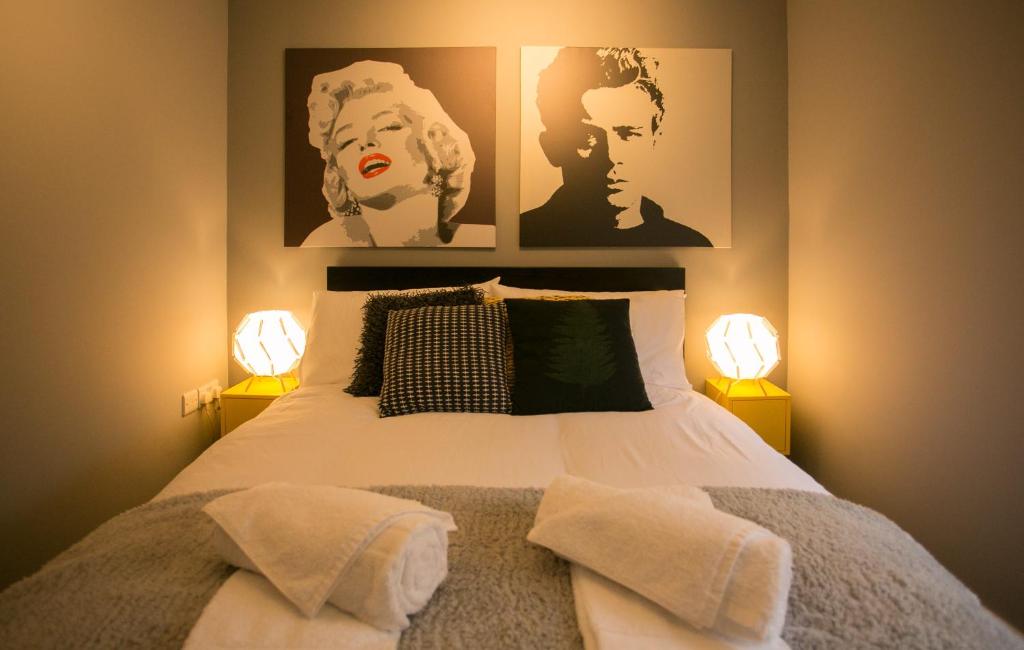 a bedroom with a bed with two lamps on it at Malone Place Apartment in Belfast