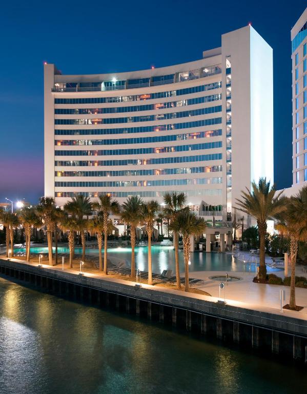 ein großes Gebäude mit Palmen vor einem Fluss in der Unterkunft Hard Rock Hotel &amp; Casino Biloxi in Biloxi