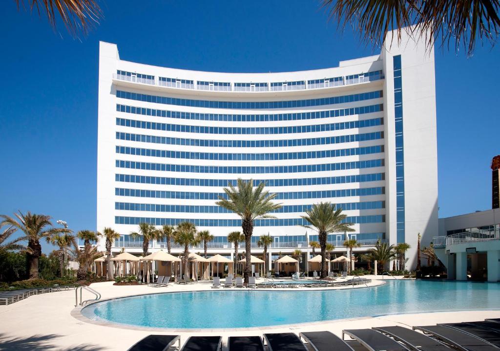 a hotel with a swimming pool in front of a building at Hard Rock Hotel & Casino Biloxi in Biloxi