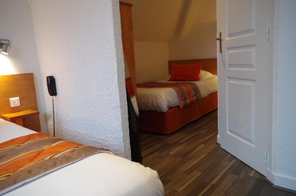 Postel nebo postele na pokoji v ubytování Logis Hotel Beaudon