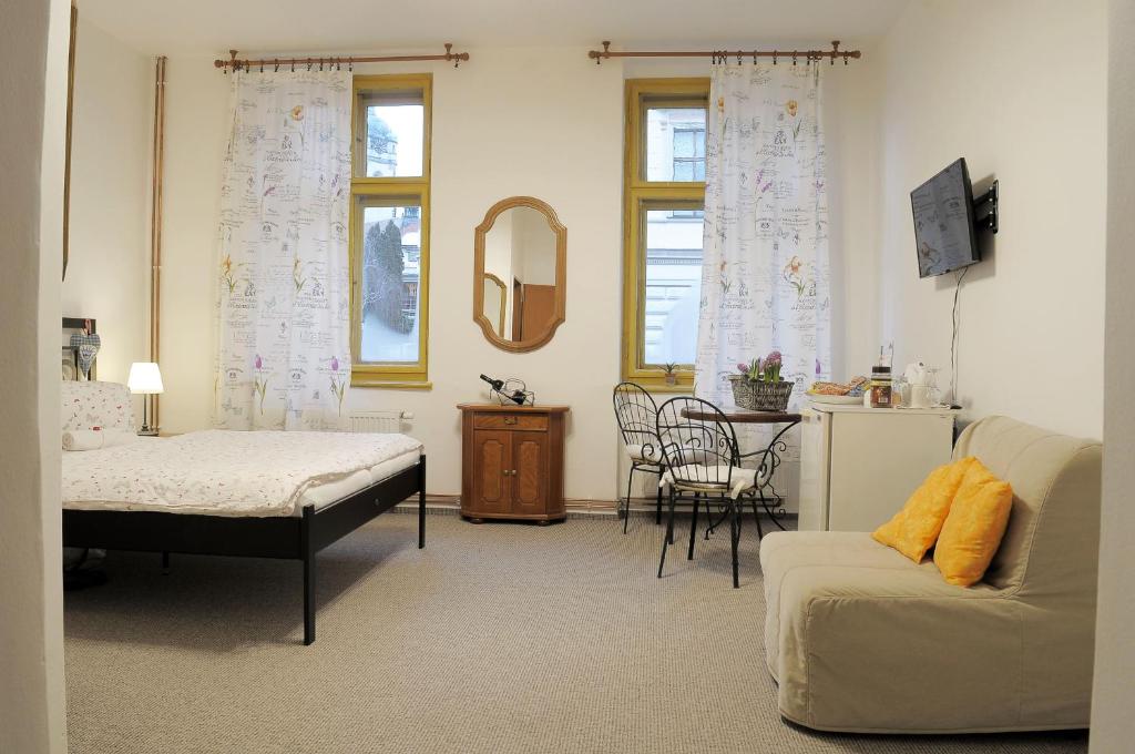 salon z łóżkiem i kanapą w obiekcie Apartmány V Podzámčí II. w Mielniku