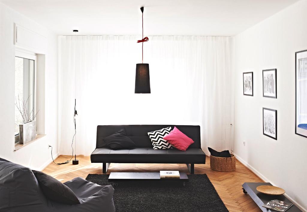 uma sala de estar com um sofá preto e uma mesa em SOON appartements em Simmern