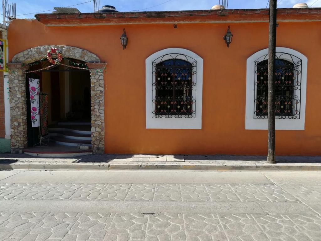 an orange building with a bunch of wine bottles at Teocalli in Teotitlán del Valle