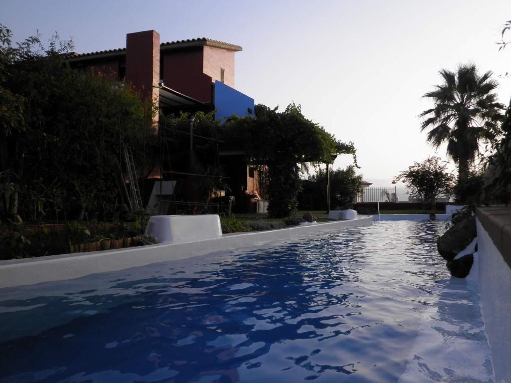 een zwembad met blauw water voor een gebouw bij Villa El Jagüel in Montañeta