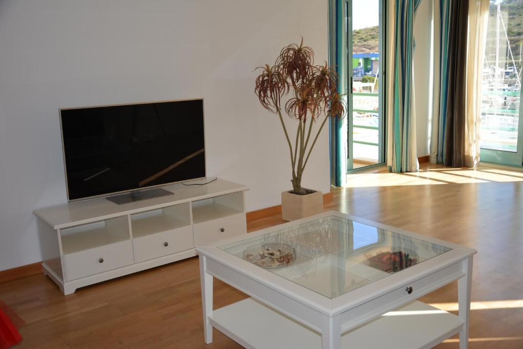 - un salon avec une télévision et une table en verre dans l'établissement Beautiful Apartment In Albufeira Marina, à Albufeira