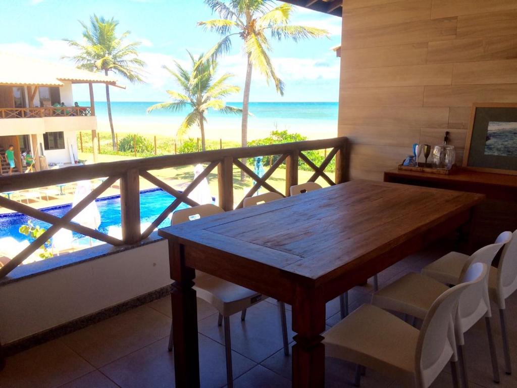 a dining room with a table and a view of the ocean at Village Beira Mar em Itacimirim in Itacimirim