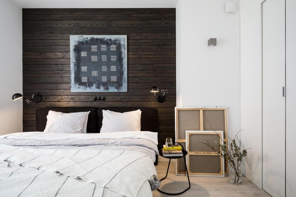 華沙的住宿－Górska Apartament，一间卧室设有一张带木墙的大床