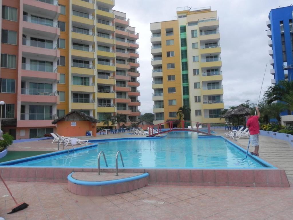 a swimming pool in the middle of some apartment buildings at Departamento Torresol Paraiso in Tonsupa