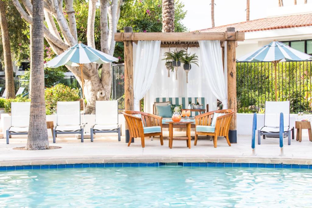 eine Terrasse mit einem Tisch und Stühlen neben einem Pool in der Unterkunft The Scott Resort & Spa in Scottsdale