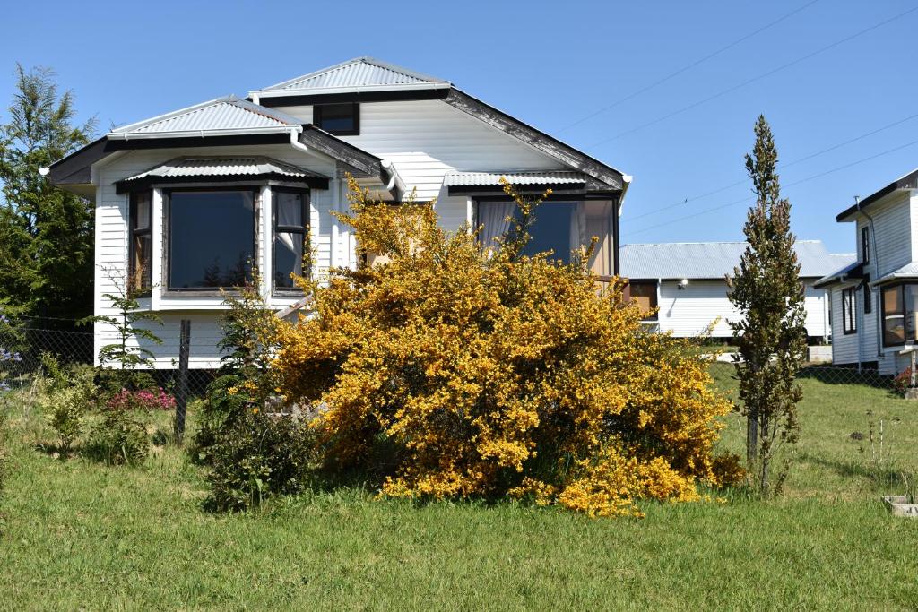 una casa con un arbusto en el patio en Cabañas Vista Tranquila Chiloé en Castro