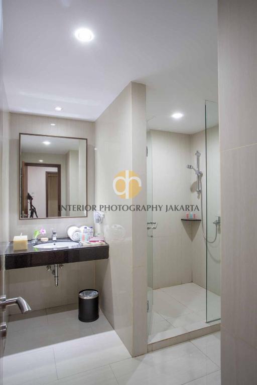 a bathroom with a sink and a shower at Orchardz Hotel Bandara in Tangerang