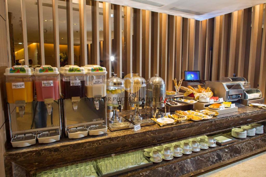 a buffet line with food and drinks on display at Orchardz Hotel Bandara in Tangerang
