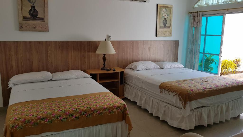 um quarto de hotel com duas camas e uma janela em Albatros Apartments em Guayaquil