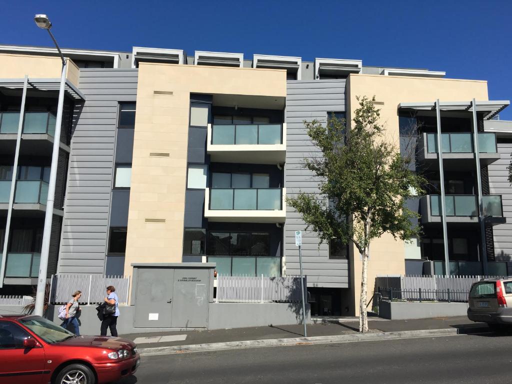 two people are standing in front of a building at Hobart Inner City Apartment in Hobart