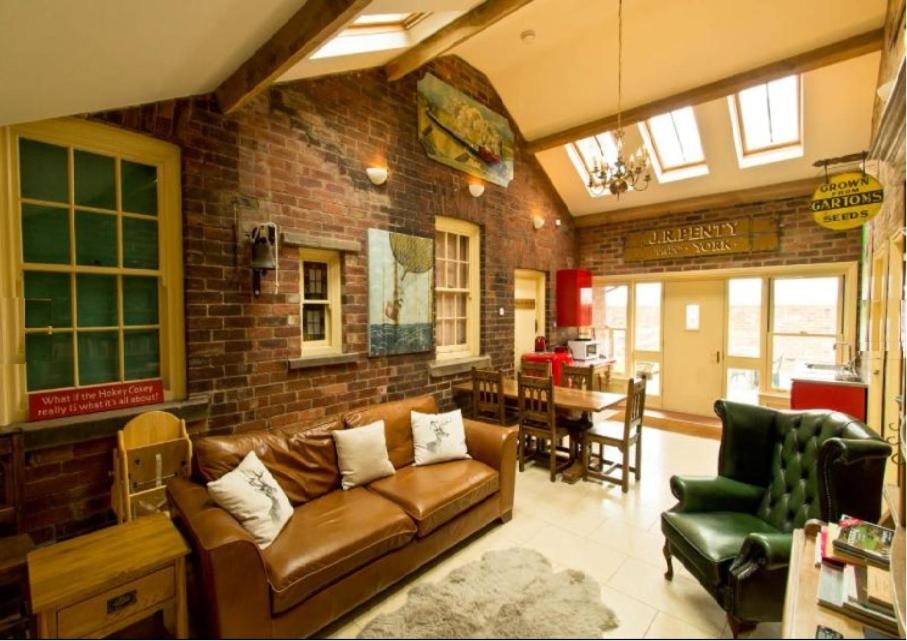a living room with a couch and a brick wall at The Annex at Oliver Farm in York