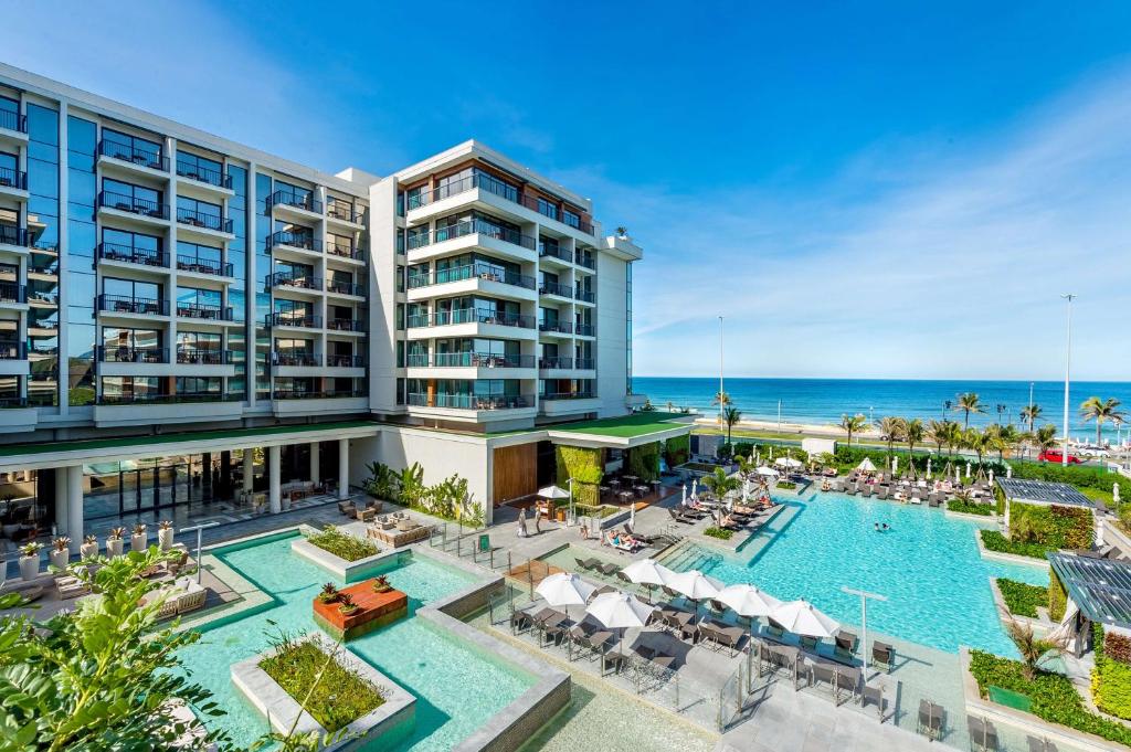 an aerial view of a resort with a pool and the ocean at Grand Hyatt Rio de Janeiro in Rio de Janeiro