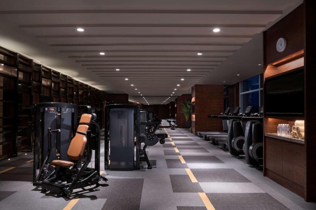 a fitness room with a row of exercise equipment at Hyatt Regency Shanghai Wujiaochang in Shanghai