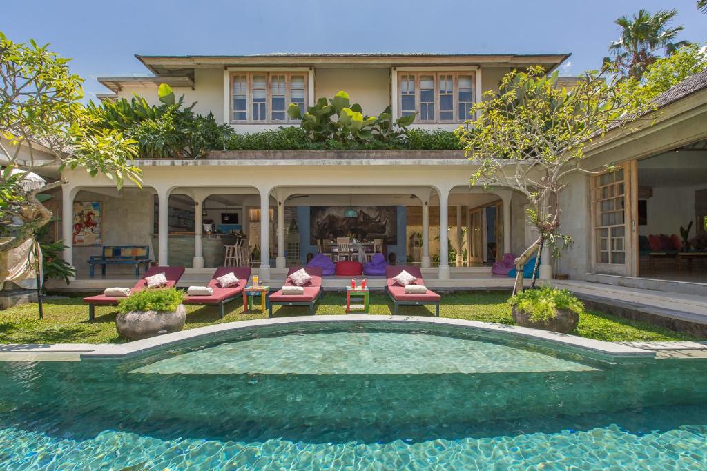 a villa with a swimming pool in front of a house at Villa Sky Li by Nagisa Bali in Seminyak