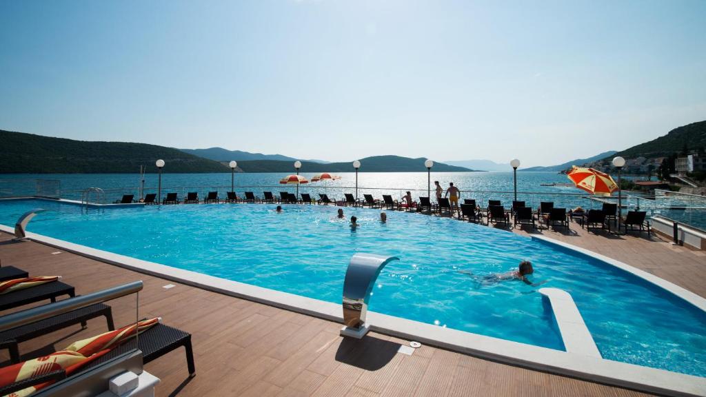 a large swimming pool with people in the water at Hotel Sunce in Neum