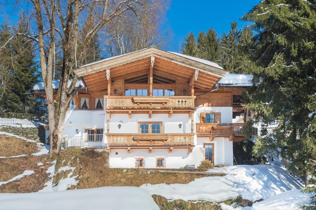 a house in the woods with snow on the ground at Das Kitz - deLuxe Chalet Valerie in Reith bei Kitzbühel