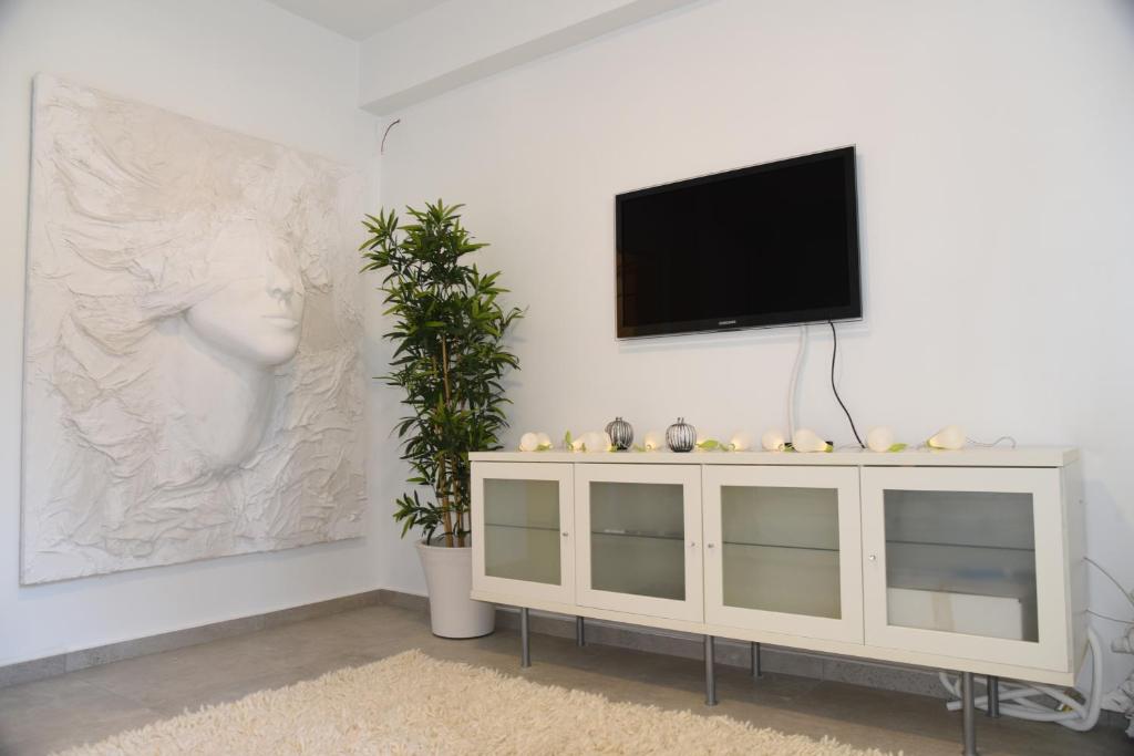 a living room with a tv on a white wall at Acropolis At Your Door in Athens