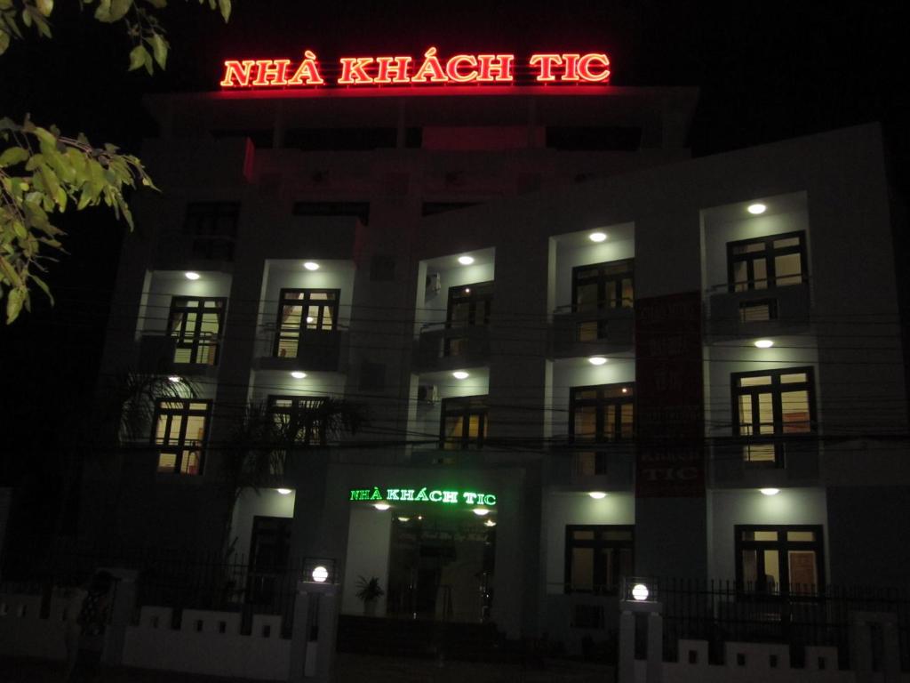 a night view of a hotel with a neon sign at Tic Guest House in Liên Trì (3)