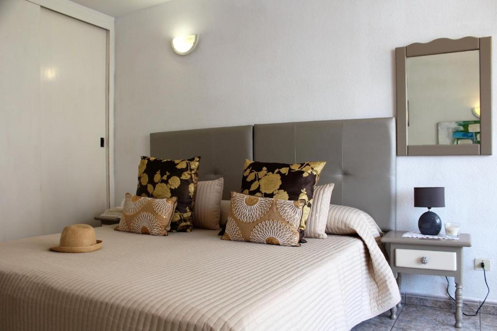 プラヤ・デ・ラス・アメリカスにあるOlympia vista mare by Holiday Worldのベッドルーム1室(壁に鏡付きのベッド1台付)
