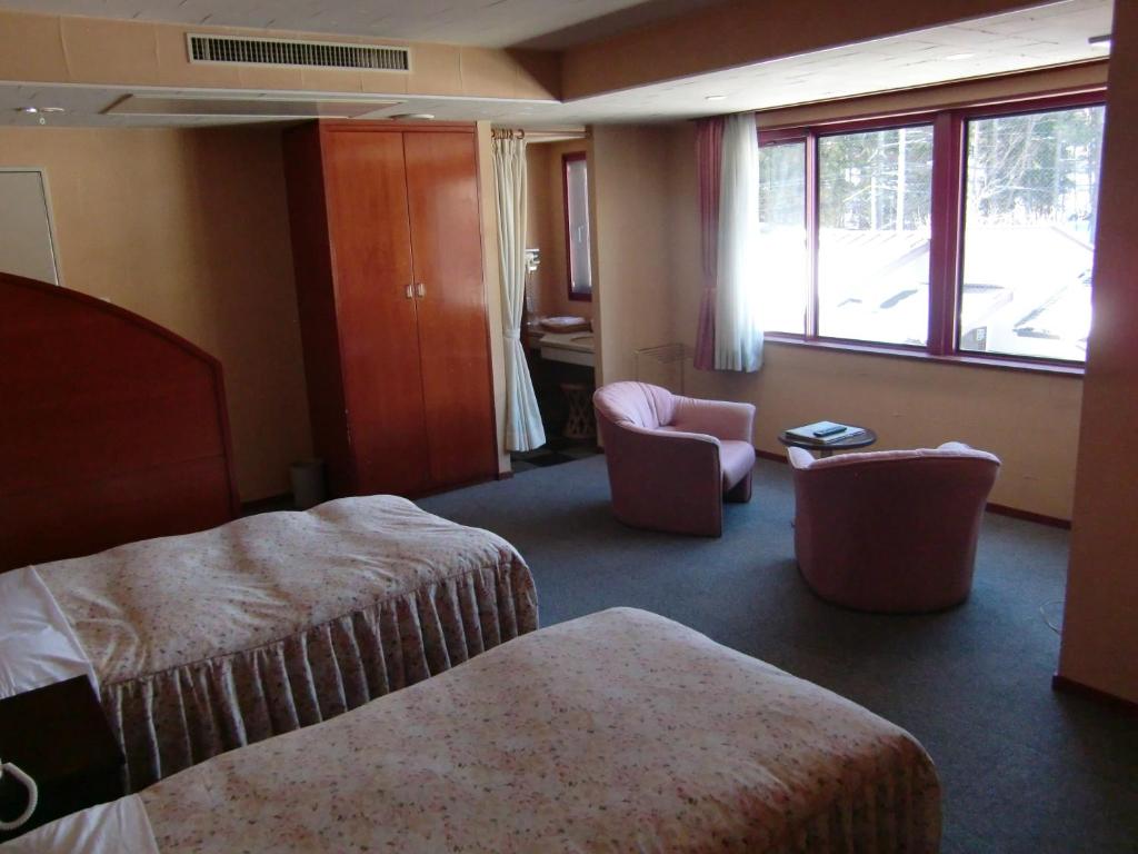 Postel nebo postele na pokoji v ubytování Hakuba Hotel Ougiya