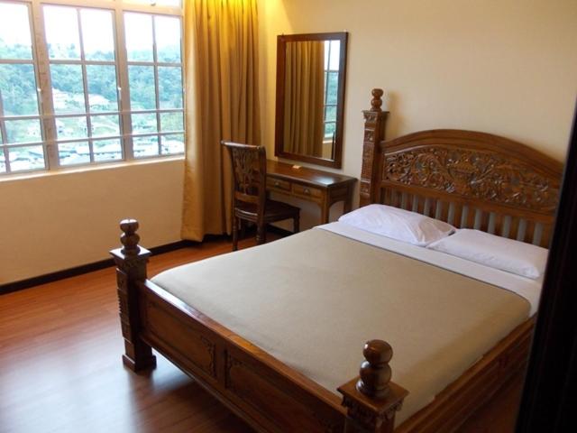 1 dormitorio con cama, escritorio y ventana en Bali Style Apartment @ Imperial Court, en Cameron Highlands