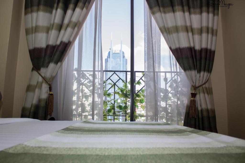 a bedroom with a bed and a large window at After 40 Hotel in Nairobi