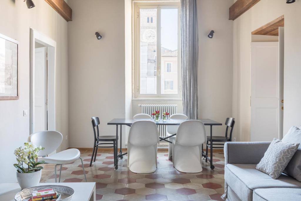 ein Wohnzimmer mit einem Tisch, Stühlen und einem Sofa in der Unterkunft Mami's Home Trastevere apt with private terrace in Rom