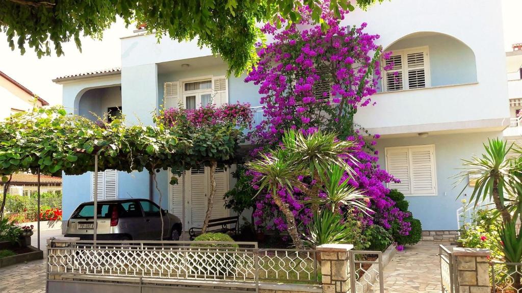 dom z fioletowymi kwiatami przed nim w obiekcie Apartment Aldo II w Poreču